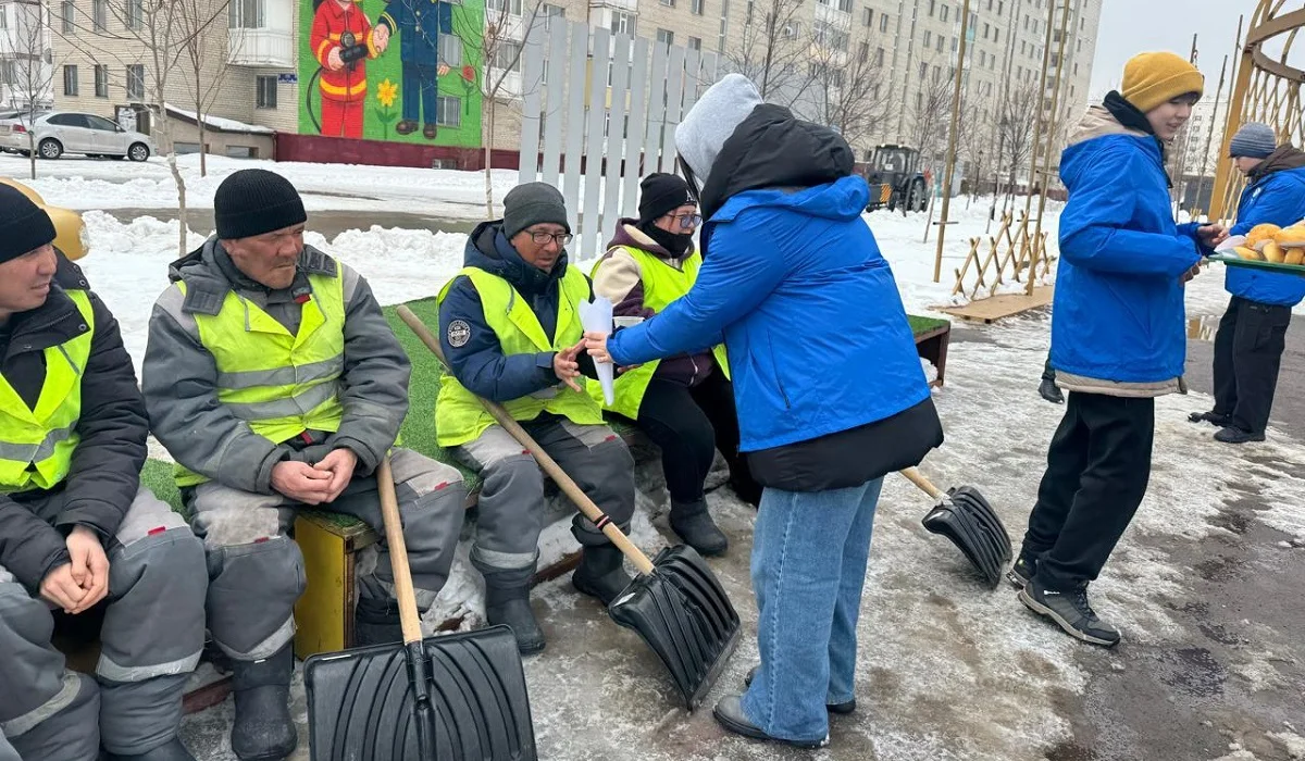 Астанада еріктілер қар күреп жүрген коммуналдық қызметкерлерге ыстық шай мен бауырсақ таратты
