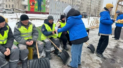 Астанада еріктілер қар күреп жүрген коммуналдық қызметкерлерге ыстық шай мен бауырсақ таратты